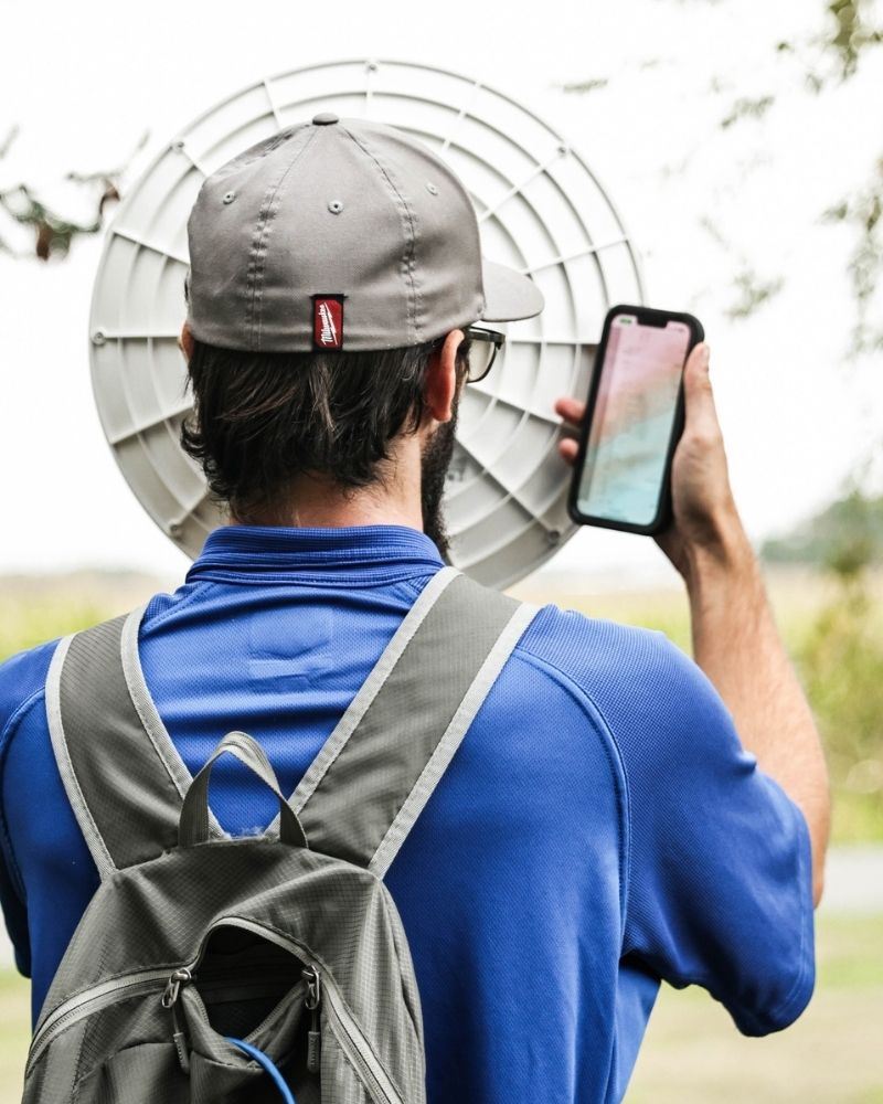 MetaLINK technician aligning a wireless dish using a smartphone signal app