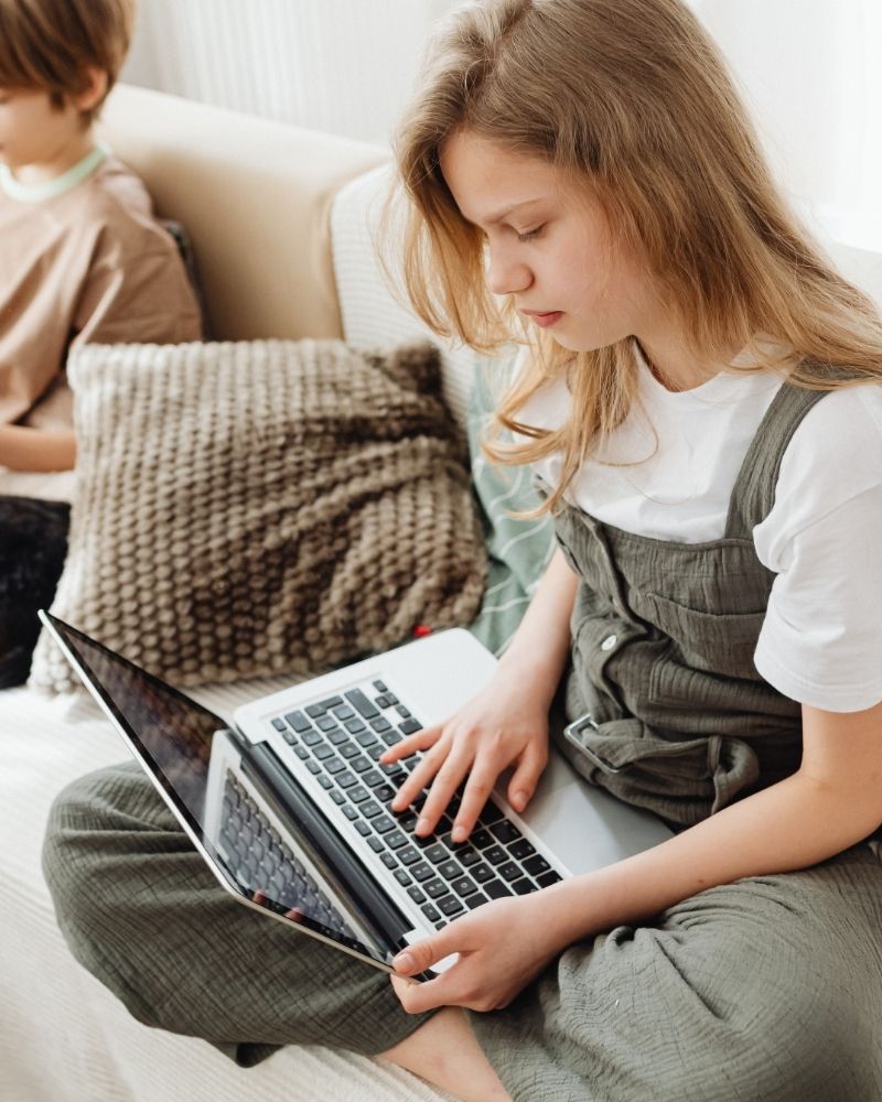 Girl using a laptop at home, enjoying fast and reliable MetaLINK internet