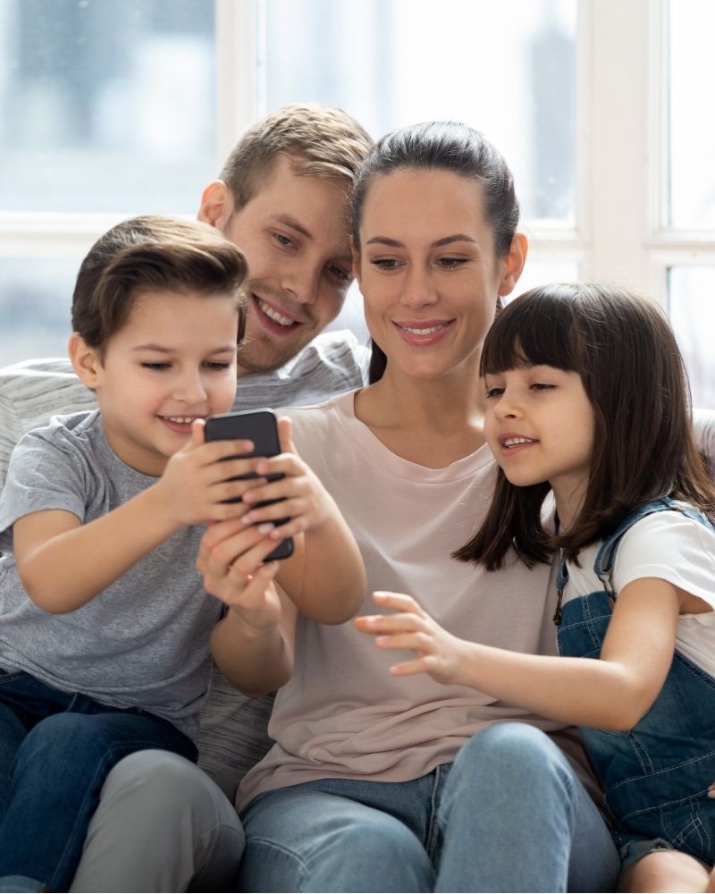 Happy family streaming and browsing together on a smartphone with MetaLINK internet