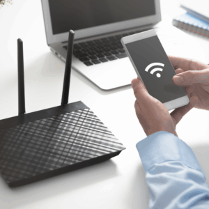 Person connecting smartphone to WiFi router, representing fast and reliable MetaLINK internet for home and mobile devices