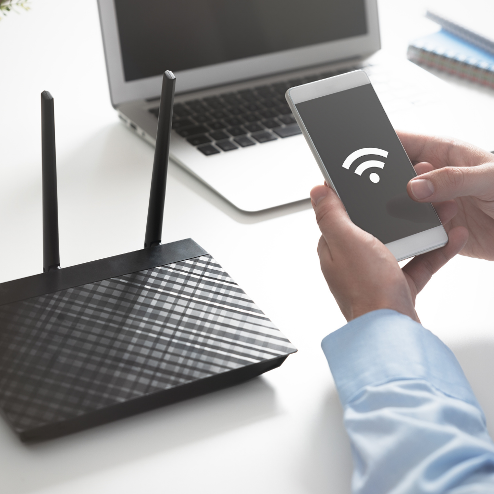 Person connecting smartphone to WiFi router, representing fast and reliable MetaLINK internet for home and mobile devices