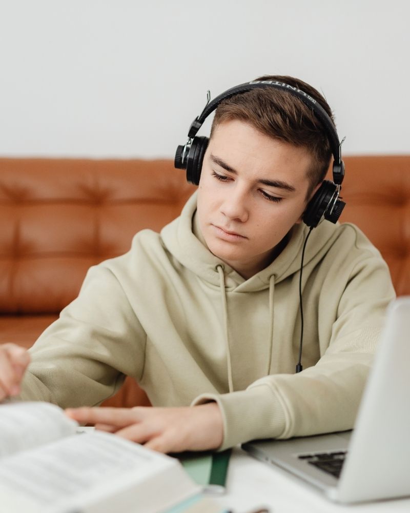 Teenage boy wearing headphones and studying online using MetaLINK internet connection