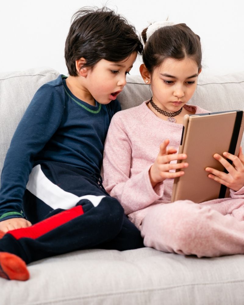 Two young kids watching a tablet together using fast and reliable MetaLINK internet