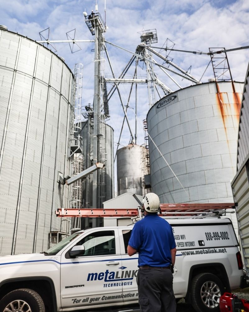 MetaLINK technician inspecting new high-speed internet tower installation at grain elevator site in Monroeville, Indiana