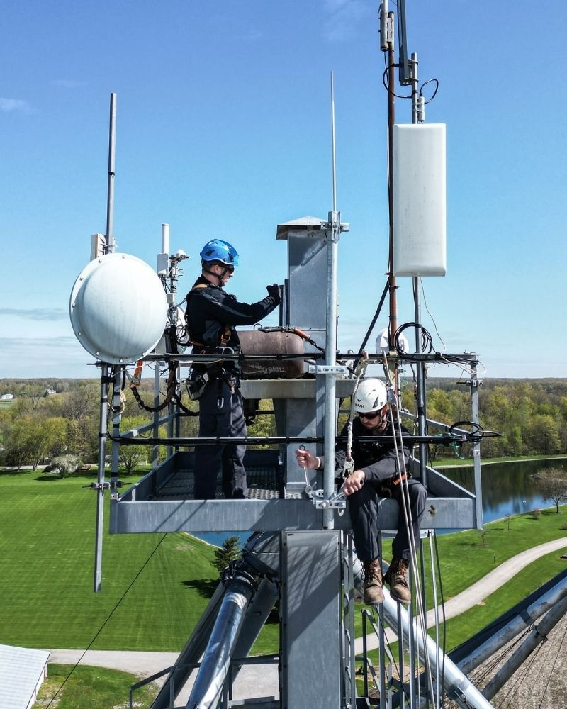 MetaLINK tower technicians working on fixed wireless equipment installation high above the ground.