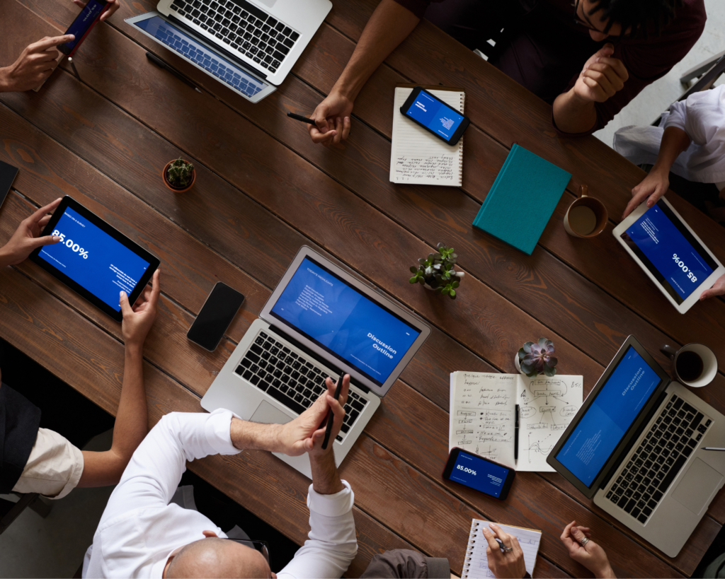 Team collaborating around table with laptops and tablets connected to MetaLINK Internet