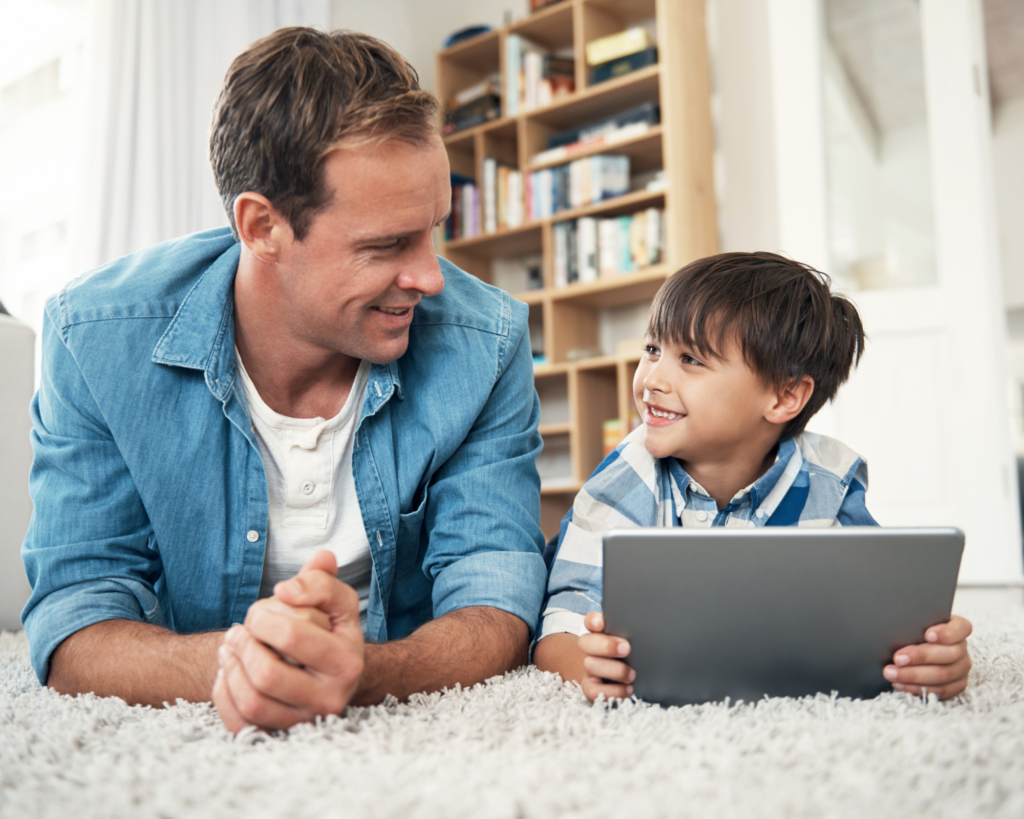 Father and son using a tablet together at home with MetaLINK residential high speed internet connection