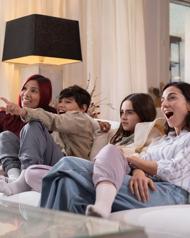 Family watching TV together in a living room, representing home entertainment experience with MetaLINK TV service