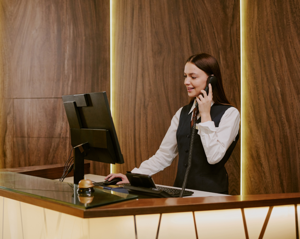 MetaLINK customer support representative assisting a customer over the phone at a front desk, highlighting local service and reliable support for TV and internet services