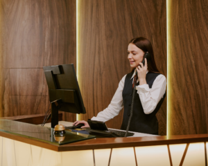 MetaLINK customer support representative assisting a customer over the phone at a front desk, highlighting local service and reliable support for TV and internet services