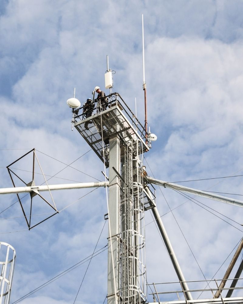 Technicians working on a wireless communication tower, representing MetaLINK network infrastructure and reliable service delivery