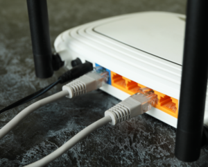 Close-up of a home WiFi router with Ethernet cables connected, highlighting reliable internet connectivity, networking equipment, and high-speed broadband service for residential users.